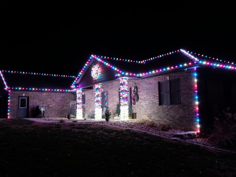 Home with warm white holiday roofline lights