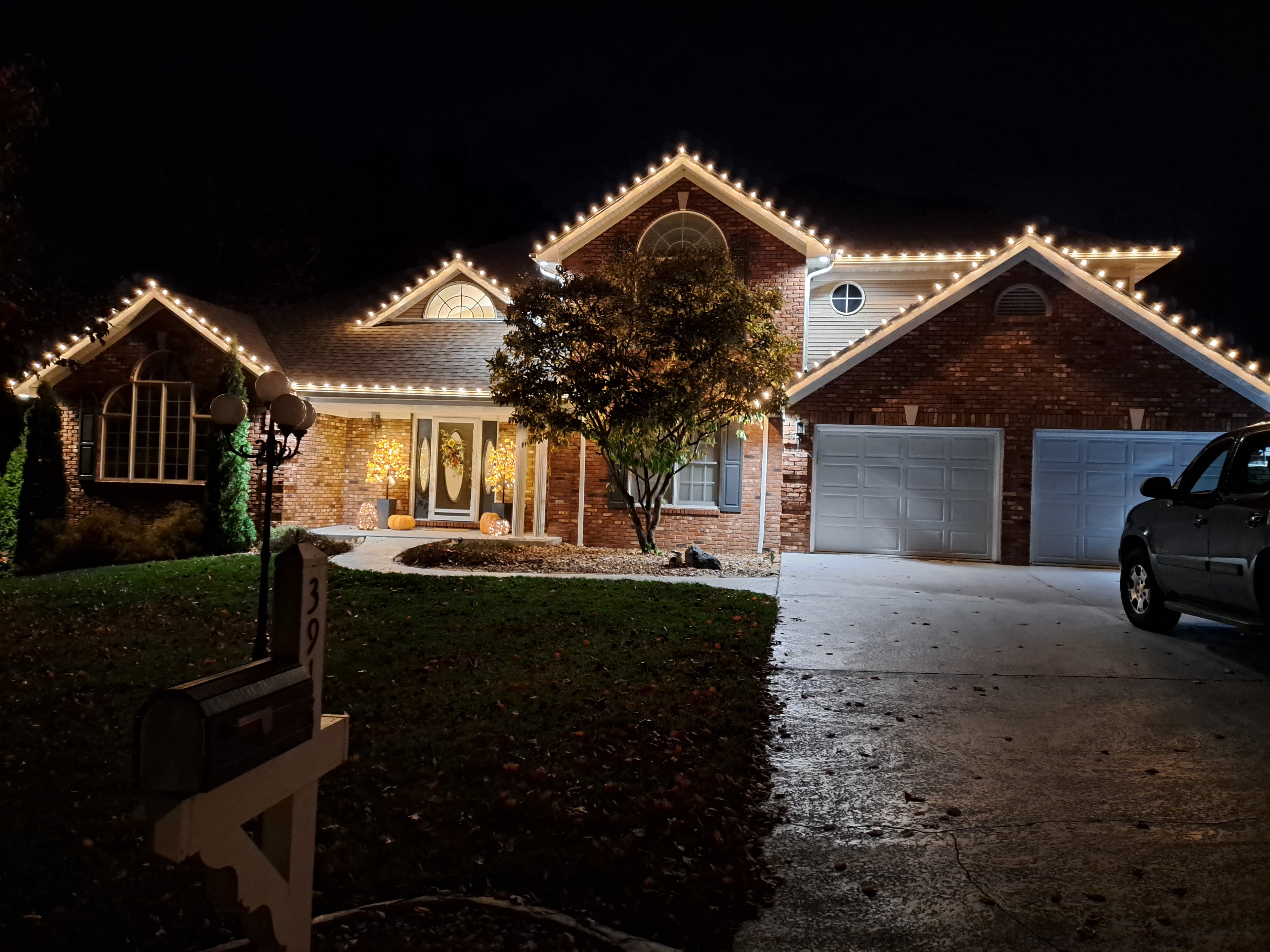 Classic white holiday lights on home roofline and windows
