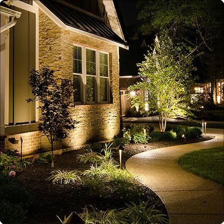 Backyard landscape lighting with water feature and garden spotlights