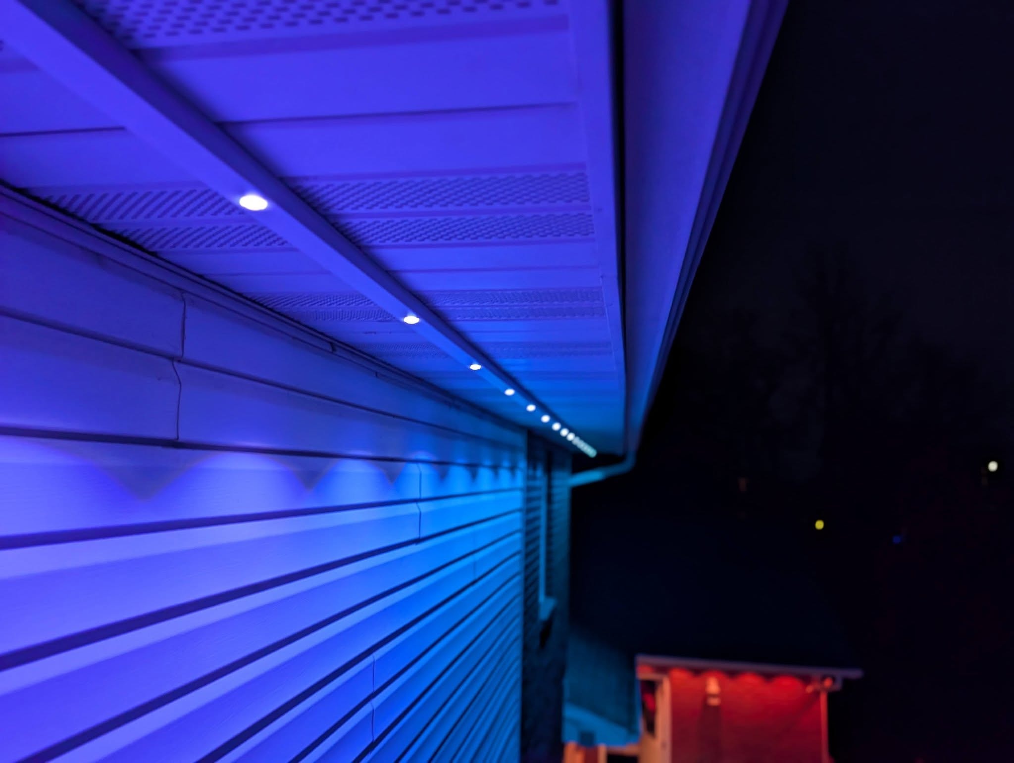 Close-up of permanent recessed soffit LED lighting in blue scene