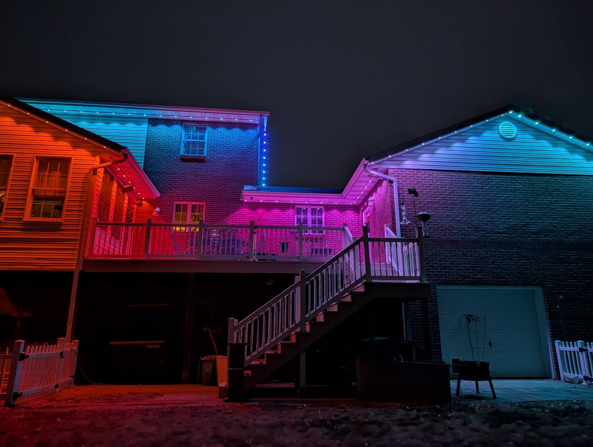 Back deck and garage with permanent red orange and teal LED roofline lighting
