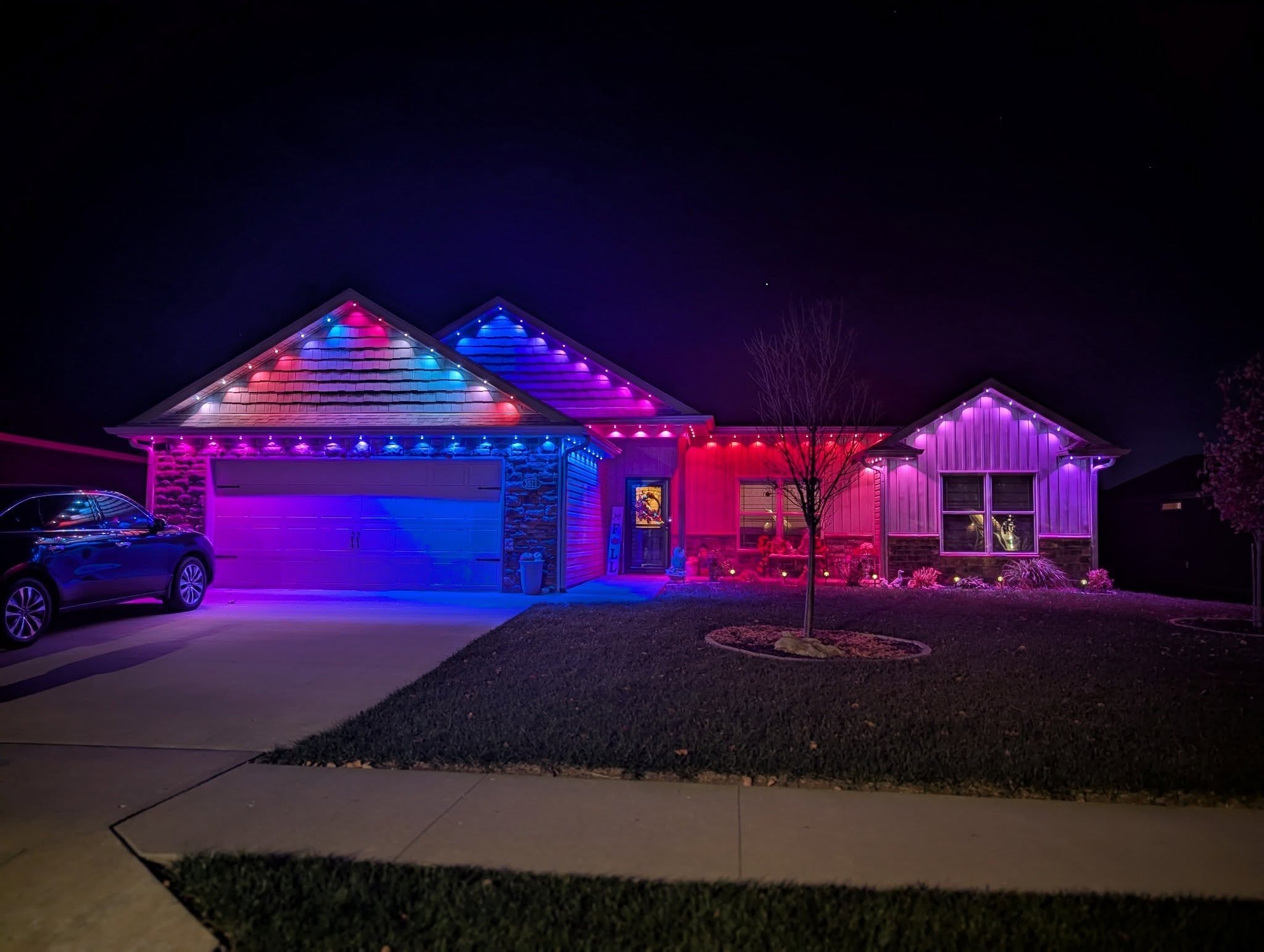 Modern ranch home with permanent RGB multicolor roofline LED lighting at night