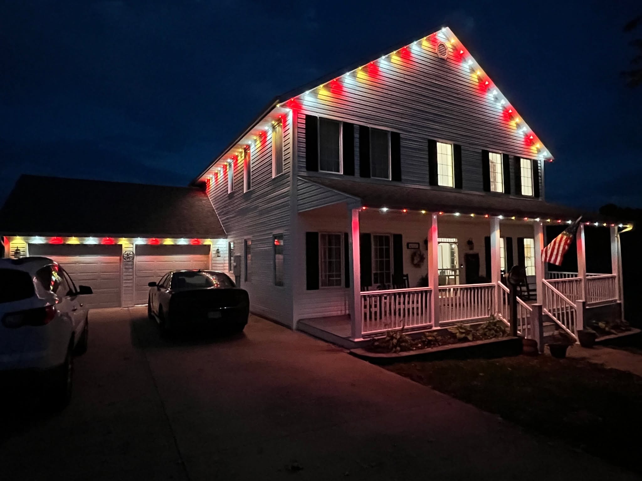 Colonial two-story home with permanent red and gold roofline LED lighting